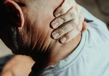 Photo of man holding his neck, who is injured
